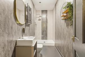 a bathroom with a sink and a toilet and a mirror at Clayton Apartments in Newcastle upon Tyne