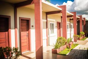 a row of houses with wooden doors and plants at Sabine's Place in Cangbaliguia