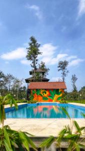 a pool at a resort with a colorful mural at Estate IV - Saffron Suite - Tea Estate Stay in Vythiri