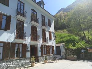 a building with balconies and tables in front of a hill at Casa Es Neres in Les