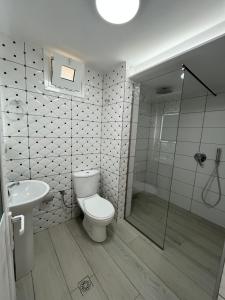 a bathroom with a toilet and a shower and a sink at Joni Apartments in Ksamil