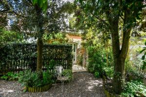 a garden with a chair and trees and a fence at Cottages Croix L'abbé, les Mouettes in Saint-Valéry-sur-Somme