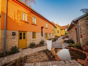 a courtyard of a house with a pond in front of it at Platán Utca - Platán Tata in Tata