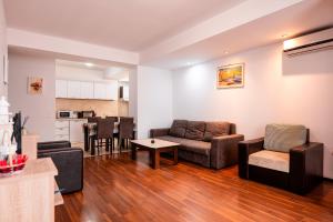 a living room with a couch and a table at Summerland Lake View Apartament in Mamaia
