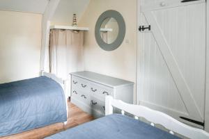 a bedroom with a bed and a dresser and a mirror at Cottages Croix L'abbé, les Mouettes in Saint-Valéry-sur-Somme