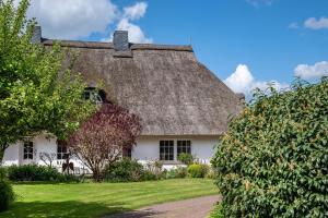 a white house with a thatched roof at Haus am See in Witzin