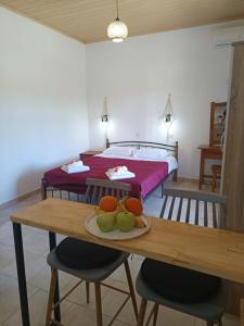 a room with a bed and a table with fruit on it at Dimosthenis Apartments in Agios Georgios +58 photos