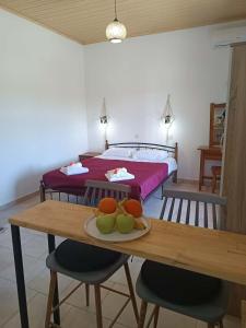 a bedroom with a bed and a table with fruit on it at Dimosthenis Apartments in Agios Georgios