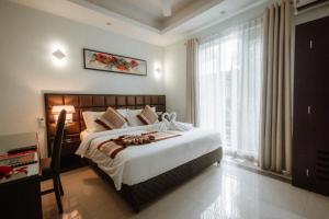 a bedroom with a large bed and a large window at Viveka Hotel Colombo in Colombo
