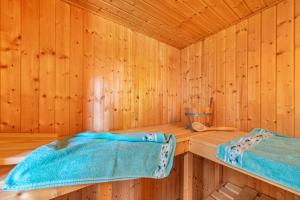 a wooden sauna with a blue blanket on a table at Haus am See in Witzin