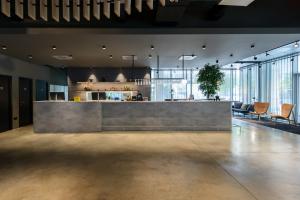 a lobby with a counter and chairs in a room at Zleep Madrid Airport in Madrid
