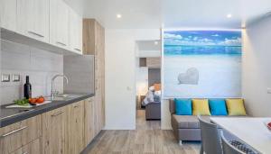 a kitchen with a living room with a couch at Camping Bijela Uvala - Roan in Poreč