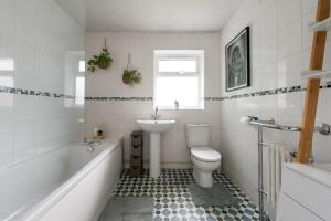 a bathroom with a sink and a toilet and a tub at Spacious 3 Bed In Rugby in Rugby