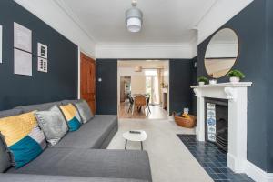 a living room with a gray couch and a mirror at Spacious 3 Bed In Rugby in Rugby