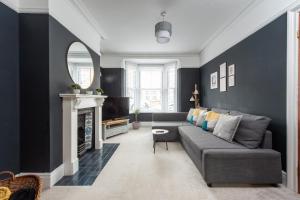 a living room with a gray couch and a fireplace at Spacious 3 Bed In Rugby in Rugby