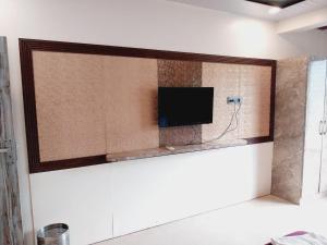 a flat screen tv on a wall in a room at Roshan Residency in Matheran