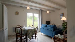 a living room with a table and a blue couch at Gite Karrikartea in Saint-Pée-sur-Nivelle