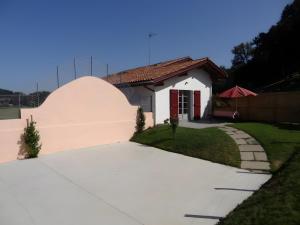 a white house with a red door and a driveway at Gite Karrikartea in Saint-Pée-sur-Nivelle +4 photos