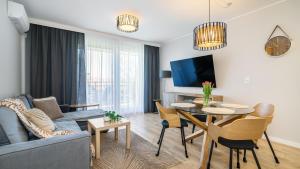 a living room with a couch and a table at SOLE MARE Apartamenty Piamola z basenem in Kąty Rybackie