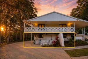 a white house with a sunset in the background at Kookaburra Guesthouse in Coffs Harbour