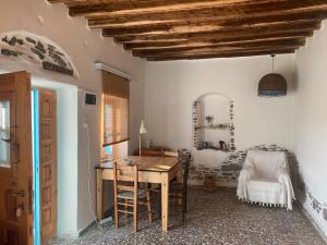 a dining room with a table and a bed at Evnomia Cycladic Home from 1912 in Mélanes