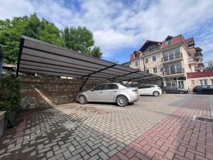 a white car parked under a black garage at Rooms Filip in Bitola