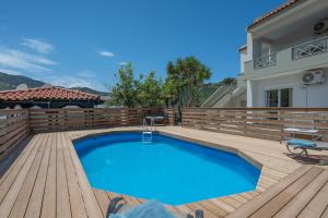 a swimming pool on a wooden deck next to a house at Villa Melenia 1 in Agia Pelagia