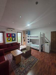 a living room with a couch and a bunk bed at Merabi Guest House in Makhinjauri