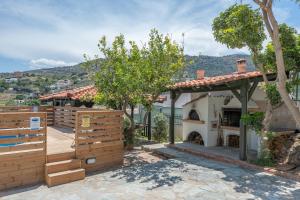 a home with a wooden fence and a house at Villa Melenia 1 in Agia Pelagia