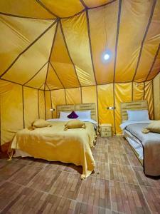 a bedroom with two beds in a tent at Camp Luxury in Merzouga in Merzouga
