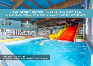 a swimming pool with a slide in the water at Domki Kropla Bałtyku in Darłowo