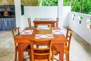 a wooden table and chairs in a room at Villa Whispering Leaves Kandy in Galaha Town