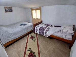a bedroom with two twin beds and a window at Stilios guesthouse in Grumas