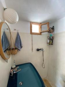 a bathroom with a blue tub and a shower at Evnomia Cycladic Home from 1912 in Mélanes