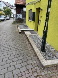 a yellow building next to a brick street at Cozy Room Echterdingen Stuttgart Airport & Messe in Leinfelden-Echterdingen