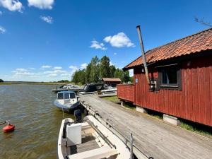 a boat is docked at a dock next to a building at Horns Skärgårdscamping in Nyköping