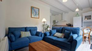 a living room with blue couches and a table at Gite Karrikartea in Saint-Pée-sur-Nivelle