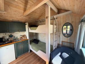 a small bedroom with a bunk bed in a tiny house at Horns Skärgårdscamping in Nyköping