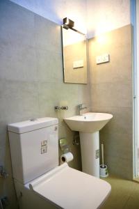 a bathroom with a white toilet and a sink at Villa Whispering Leaves Kandy in Galaha Town
