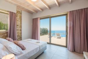 a bedroom with a bed and a view of the ocean at Flower Village in Chania +274 photos