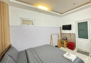 a bedroom with a bed and a flat screen tv at Thanh 57 TKH Hotel - Giá mềm ngay bên chợ Đà Lạt in Da Lat +8 photos