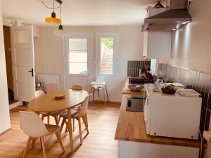 a kitchen with a wooden table and a table and chairs at Cap d'Equih' in Équihen-Plage