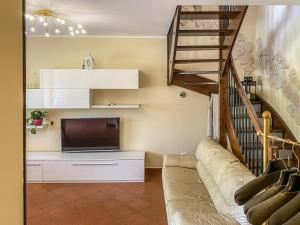 a living room with a couch and a television at Casa Le Marie in Barberino di Mugello