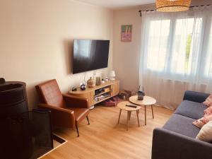 a living room with a couch and a tv at Cap d'Equih' in Équihen-Plage