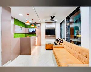 a living room with a couch and a tv at Ganges Pride Hotel in Haridwār