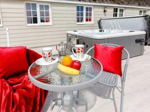 a table with fruit on a patio with a hot tub at 1 Bed in Cinderford oc-88271 in Cinderford +5 photos