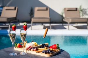 a tray of food and wine glasses next to a pool at Amfi Luxury Villa 4BR with Private Pool by Villa Mana Gers in Sarakinádhon