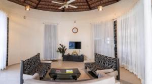 a living room with chairs and a table and a ceiling at WayFare Stud Farm & Resort in Nashik