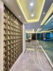 a hallway in a building with a wall of glass at Kaloka City Hotel Bima in Bima