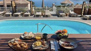 a table with food and drinks next to a swimming pool at Résidence Aigue Marine in Coti-Chiavari